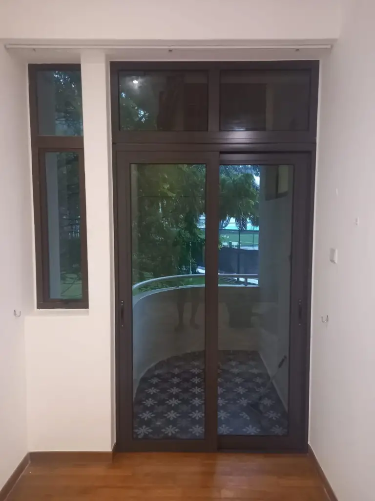 Dark-framed soundproof sliding glass door with transom panel installed in a Singapore home